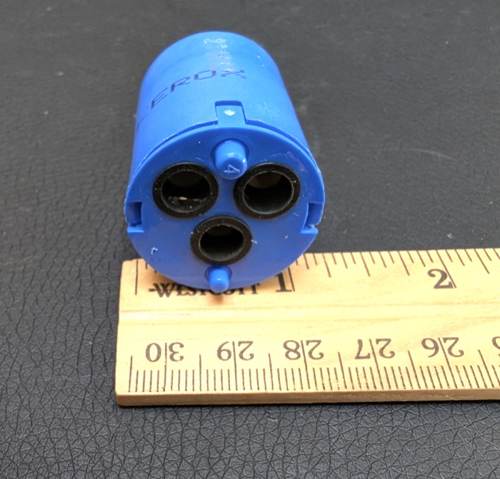 Cartridge face showing outlet holes next to a ruler